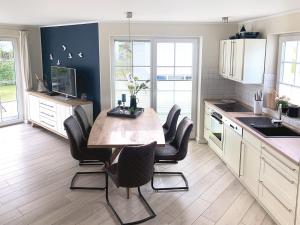 a kitchen with a wooden table and black chairs at Ferienhaus Am Strand in Zingst