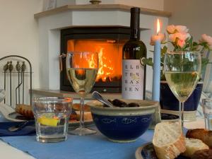 a table with wine glasses and a bottle of wine at Ferienhaus Am Strand in Zingst +6 photos