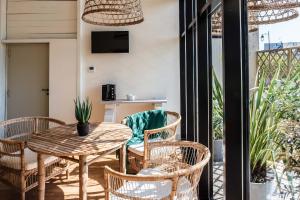 een patio met een tafel en stoelen en een televisie bij Hôtel Restaurant de Bouilhac, Spa & Wellness - Les Collectionneurs in Montignac