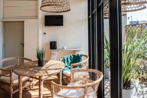 une terrasse avec une table, des chaises et une télévision dans l'établissement Hôtel Restaurant de Bouilhac, Spa & Wellness - Les Collectionneurs, à Montignac