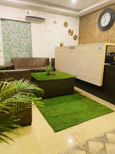 een lobby met een receptie met groen gras bij Arabian Sea Beach Resort in Morjim