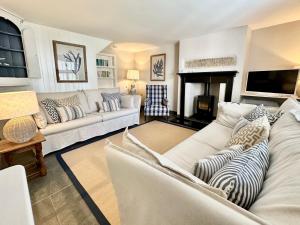 a living room with white furniture and a fireplace at Laurel Cottage Sandsend in Sandsend