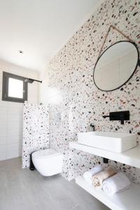 een witte badkamer met een wastafel en een spiegel bij Green Hill Thassos in Skala Potamias