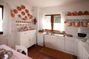 - une cuisine avec des placards blancs et un évier dans l'établissement Villa Piera, à Belluno