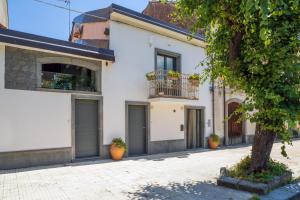 Casa blanca con balcón y árbol en Sikelia Relais, en Linguaglossa