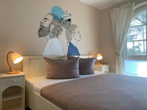 a bedroom with a bed with two women painted on the wall at Ferienhaus Am Strand in Zingst
