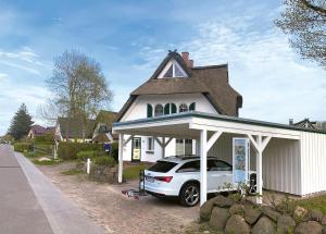 a white car parked in front of a house at Ferienhaus Am Strand in Zingst