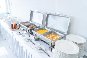 a buffet table with plates and food on it at Oriole Residence - Suvarnabhumi Airport in Ban Khlong Thewa