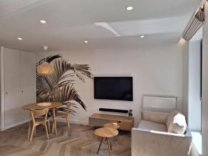a living room with a couch and a table and a tv at New Funcional Easy Stay High Standard Kraków apartment free garage parking in Kraków