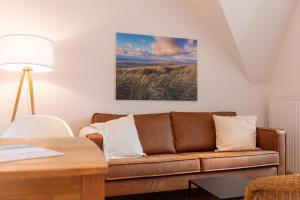 sala de estar con sofá y mesa en Ferienhaus Canvas Canvas Carolinensiel FeWo "Wangerooge", en Wittmund