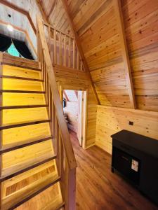 a staircase in a cabin with wooden walls and wooden floors at Elegant Bungalov in Rize