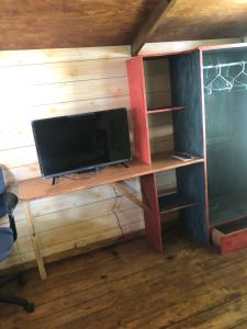 TV sentada en un escritorio de madera en una habitación en Ginger Lodge Cottage, Peters Rock, Woodford PO St Andrew, Jamaica - this property is not in Jacks Hill en Jacks Hill