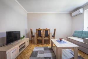 a living room with a couch and a tv at Guest House - Axios in Gevgelija