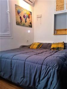 a bed in a bedroom with a blue comforter at Loft PLAYA -60m- & TRABAJO -online- in Almería