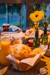 ポルト・アレグレにあるHotel Laghetto Stilo Higienópolisの食べ物のバスケットとオレンジジュース1杯付きのテーブル