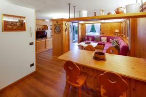 a kitchen and living room with a table and a couch at Casa Marmorata in Cortina dʼAmpezzo