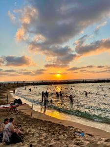 um grupo de pessoas na água em uma praia em КВАРТИРА У МОРЯ! em Haifa
