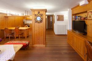 a living room with a television and a dining room at Casa Marmorata in Cortina dʼAmpezzo +15 photos