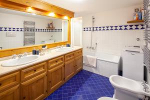 コルティーナ・ダンペッツォにあるCasa Marmorataのバスルーム(洗面台2台、バスタブ、トイレ付)