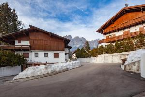 a road in front of two wooden buildings at Casa Marmorata in Cortina dʼAmpezzo