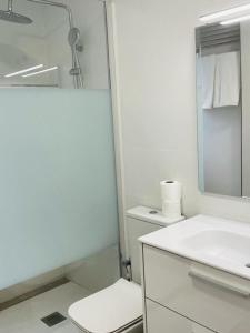 Baño blanco con aseo y lavamanos en C1 Madrid, Zona exclusiva en Madrid