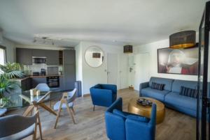 a living room with a blue couch and a table at MYAPPARTBORDEAUX in Bordeaux