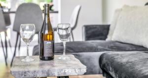 a bottle of wine and two wine glasses on a table at Dudley - Stylish 3 Bedroom Sleeps 6 Wi-Fi - JRR Stays in Woodside