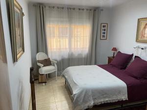 una camera con un letto e una sedia e una finestra di Big & cozy beach canet de Mar a Canet de Mar