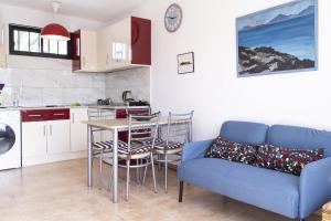 a living room with a blue couch and a kitchen at Piso Dunas Blu - Carpe Mundi in Corralejo