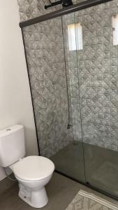 a bathroom with a toilet and a glass shower at CHALÉS VALE DO LAGO in Capitólio +24 photos