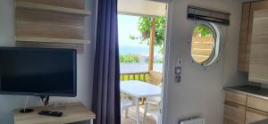 uma sala de estar com uma televisão e uma varanda em El Carlitos em Arenys de Mar