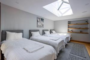 three beds in a room with a skylight at Kingsley Paddocks in Chew Stoke