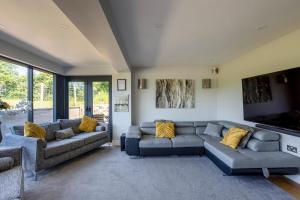 a living room with two couches and a tv at Kingsley Paddocks in Chew Stoke