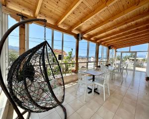 a porch with a swing and a table and chairs at Joni Apartments in Ksamil
