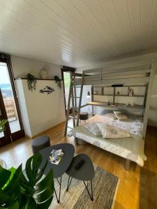 ein Schlafzimmer mit einem Etagenbett, einem Tisch und Stühlen in der Unterkunft Au Doubs Village in Métabief