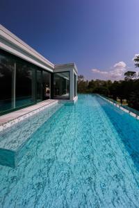 a swimming pool in front of a house at Villa Bauhaus Wellness Apart-Hotel in Siófok
