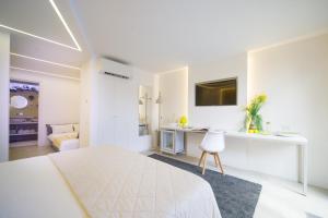 Habitación blanca con cama y escritorio en Le Monachelle Luxury, en Éboli