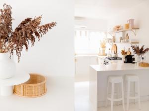 a white kitchen with a counter and stools at Boho Beach Retreat in La Lucia, Umhlanga in Durban