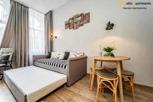 ein Wohnzimmer mit einem Bett und einem Tisch in der Unterkunft Baltic Apartments - Willa Carmen in Świnoujście