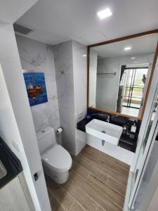 a bathroom with a toilet and a sink and a mirror at ABoutNont HOTEL & MANSION in Nonthaburi