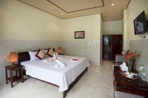 a bedroom with a large white bed in a room at Sunlight Bungalow in Phu Quoc