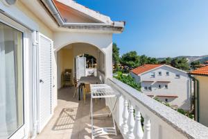 un balcone di una casa con tavolo e sedie di Apartments Miranda a Lopar