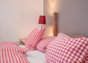 a bed with red and white pillows and a lamp at Boutique-Hotel Weigels Bergfreiheit in Winterberg