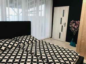 um quarto com um edredão preto e branco numa cama em Villa Rosé Lehnice em Lehnice