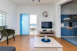 a living room with a tv and a couch and a table at Apartments Miranda in Lopar