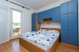 a bedroom with blue cabinets and a large bed at Apartments Miranda in Lopar +94 photos