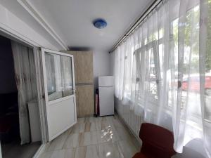 a room with a hallway with a window and a refrigerator at Apartament Beatrice in Năvodari