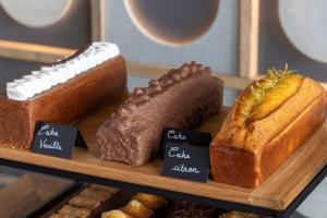 a bunch of different types of bread on a wooden tray at Les Regalia Hôtel & Spa in Sainte-Lucie de Porto-Vecchio