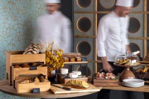 a chef standing in front of a table with food at Les Regalia Hôtel & Spa in Sainte-Lucie de Porto-Vecchio