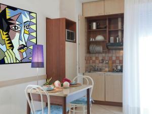a kitchen with a table and chairs in a room at Vibrant Apartment in Rimini with Balcony in Rimini